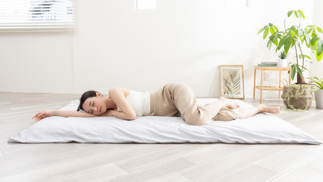 A woman sleeping on a Japanese-style futon mattress.